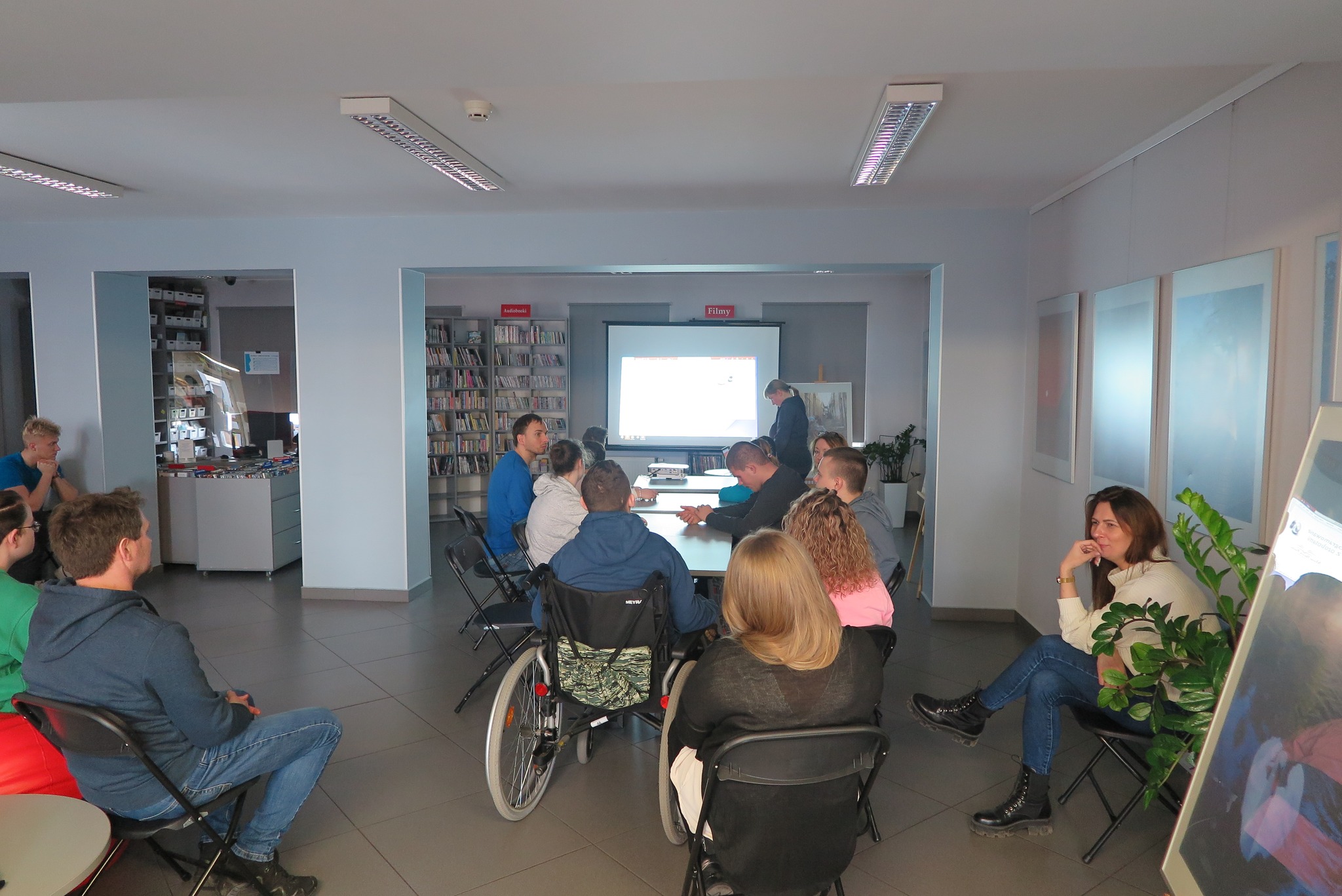 wychowankowie z Orewu siedzą przy długim stole w Mediatece, oglądają prezentację  jak programować ozoboty