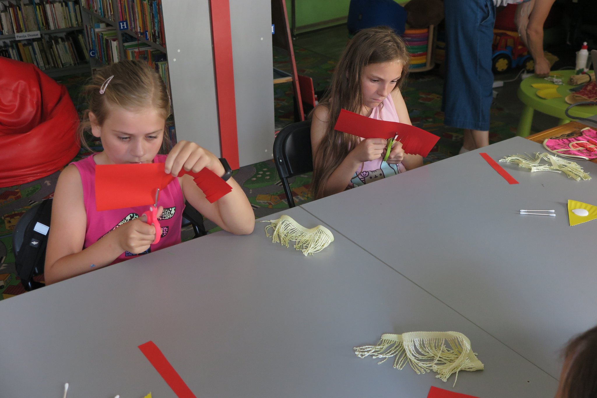 uczestnicy warsztatów podróżniczych z Anną Jaklewicz wykonują chińskie lampiony z czerwonego papieru