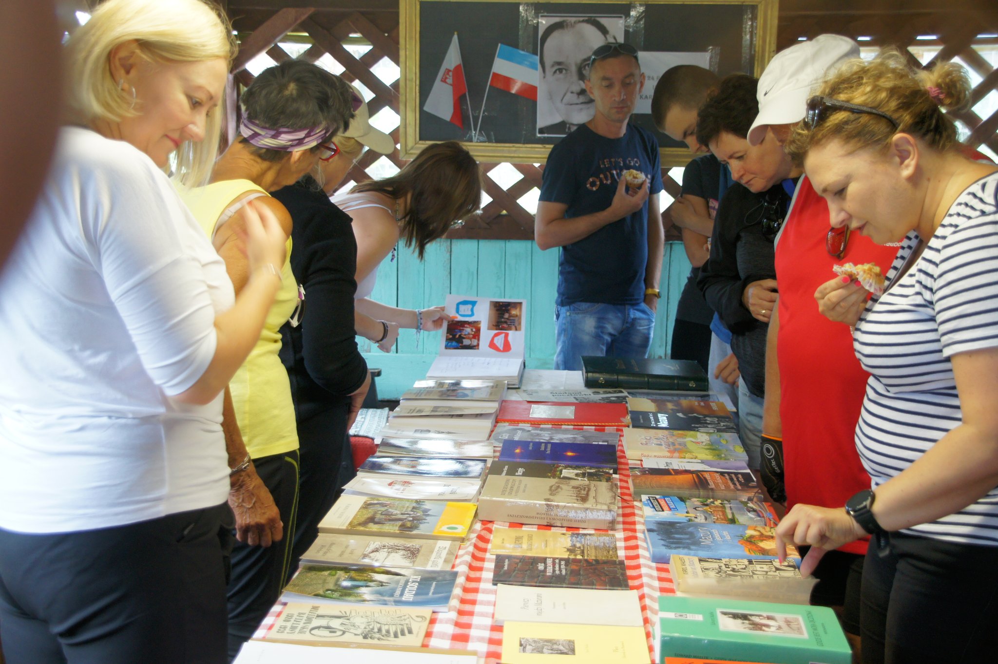 uczestnicy rajdu oglądają książki wyłożone na stole dotyczące karola Małłka
