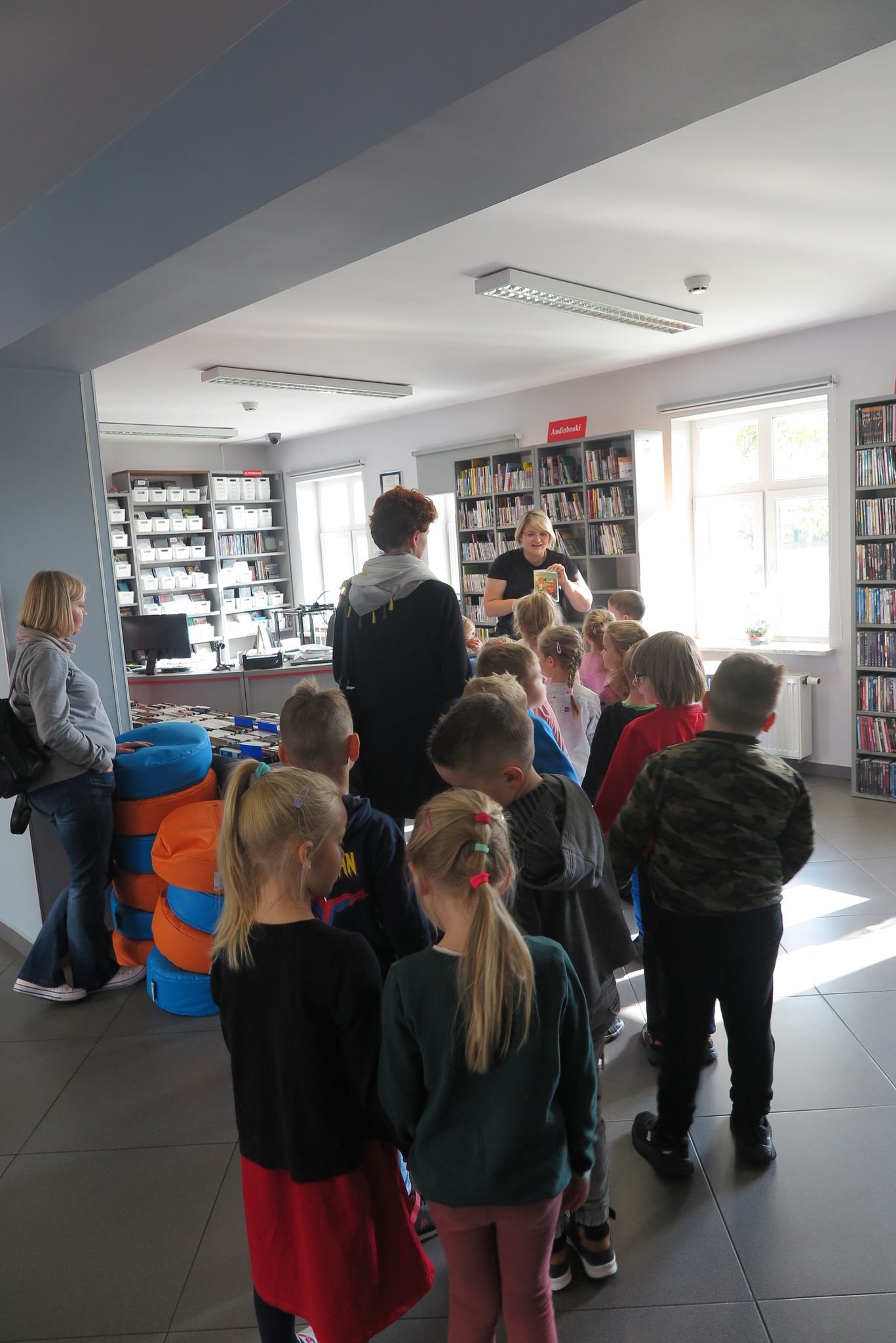 grupa dzieci z przedszkola jest oprowadzana przez bibliotekarkę po MEDIATECE
