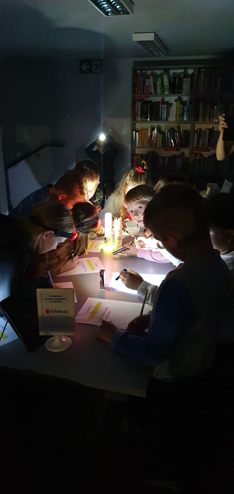 dzieci rozwiązują przy latarkach zagadkę zaginionego misia Szymona 