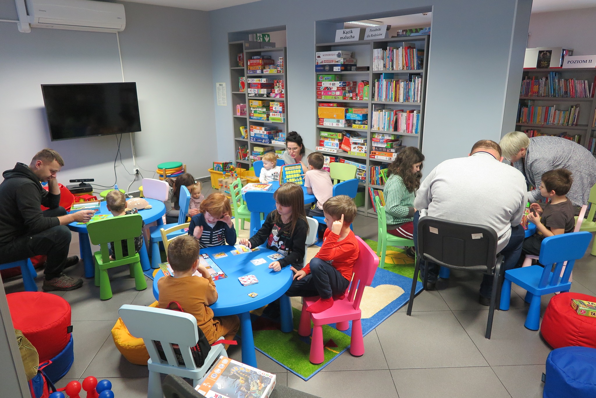 rodziny grające w gry planszowe w bibliotece